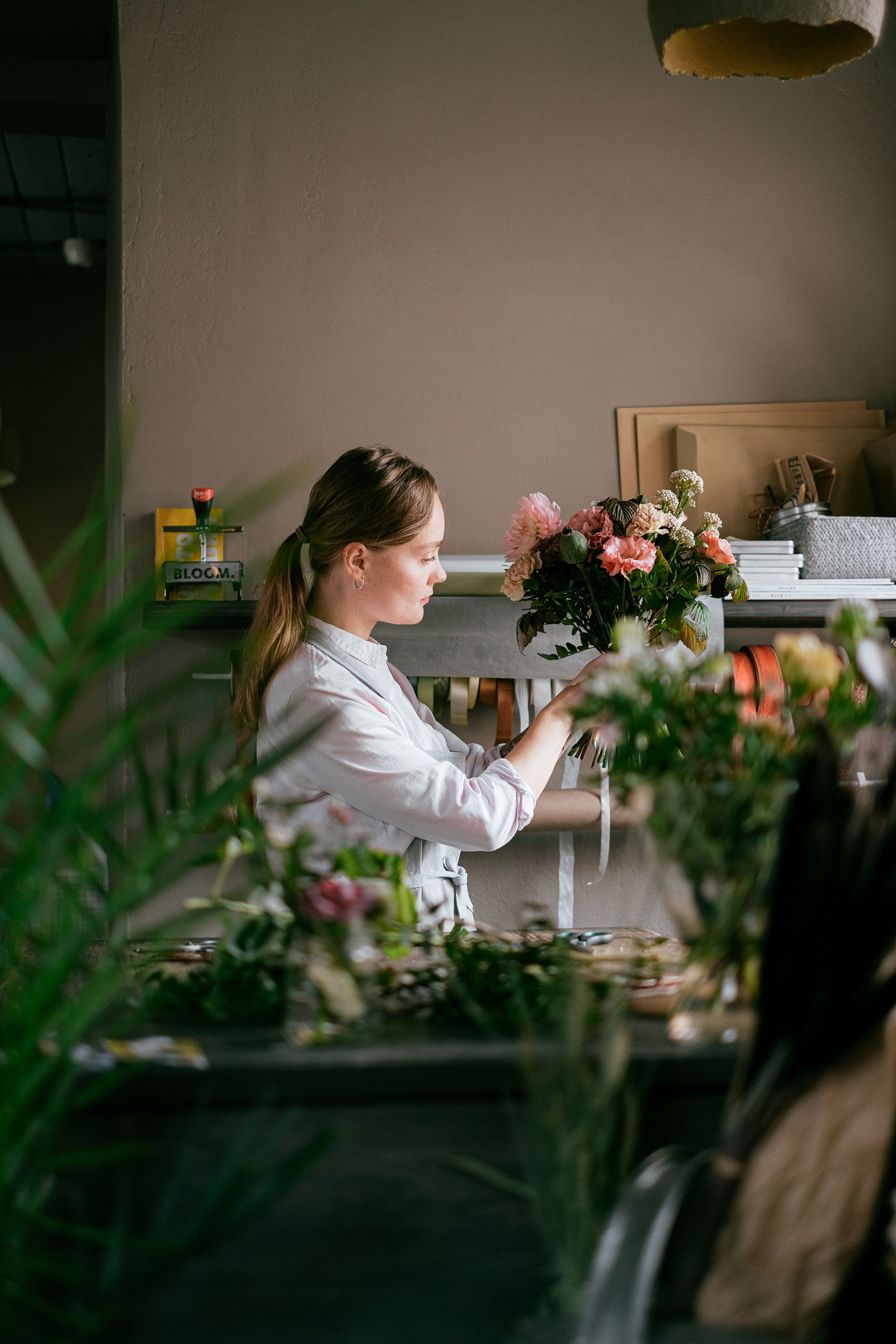 Floristin bindet einen Strauß im Atelier